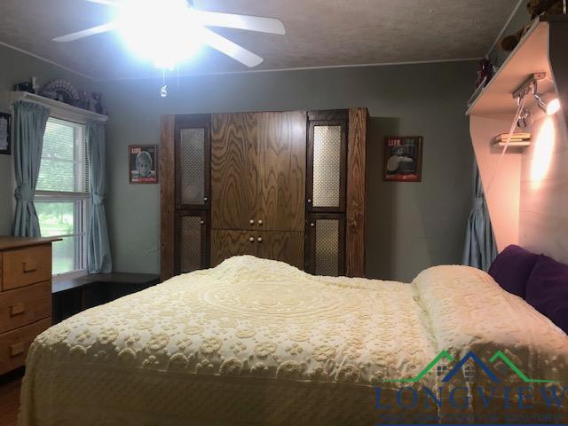 bedroom featuring ceiling fan and a textured ceiling