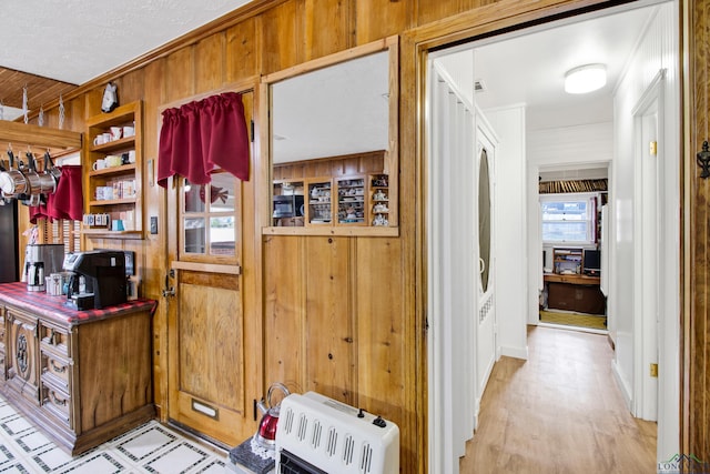 office area featuring light wood-type flooring, heating unit, and wood walls