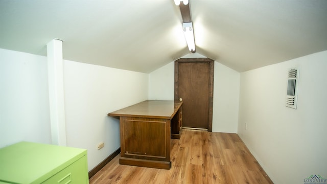 additional living space with light hardwood / wood-style floors and lofted ceiling