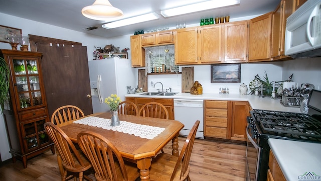 kitchen with white appliances, light hardwood / wood-style flooring, and sink