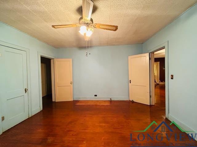 unfurnished bedroom with ceiling fan and dark hardwood / wood-style floors