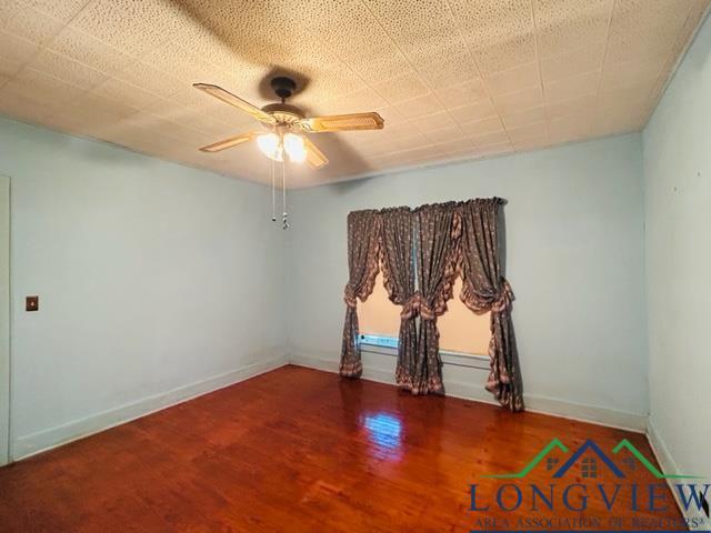 empty room featuring hardwood / wood-style flooring and ceiling fan