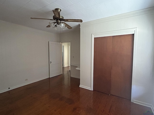 unfurnished bedroom featuring ceiling fan, a closet, baseboards, and wood finished floors