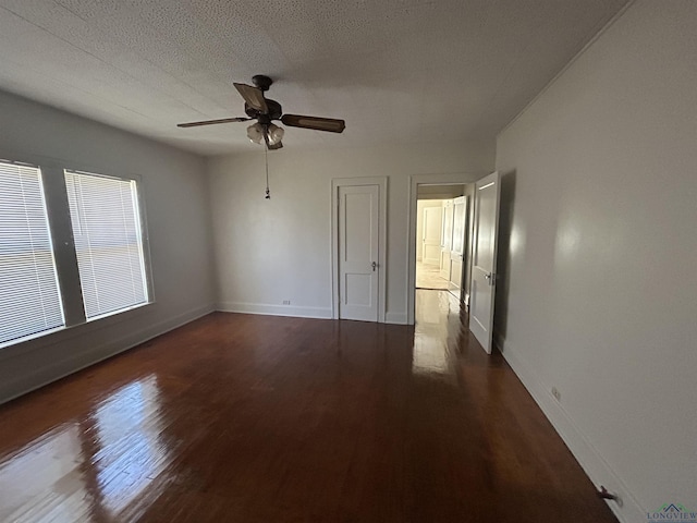 unfurnished bedroom featuring a textured ceiling, wood finished floors, a ceiling fan, and baseboards