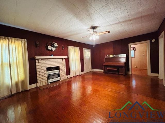 unfurnished living room featuring ceiling fan, a fireplace, and hardwood / wood-style flooring