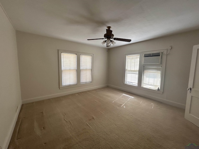 empty room with a wall unit AC, light colored carpet, and baseboards