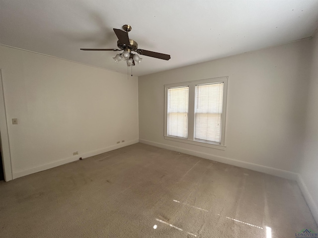 empty room with a ceiling fan, light colored carpet, and baseboards