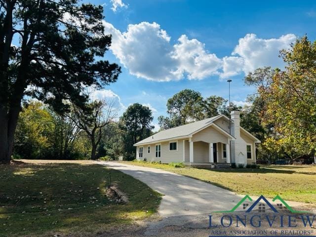 view of front of property featuring a front lawn and a chimney