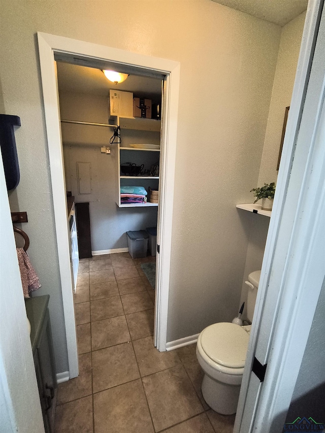 1101 N Idlewood Dr, White Oak, TX 75693 - bathroom with tile patterned floors, toilet, and baseboards