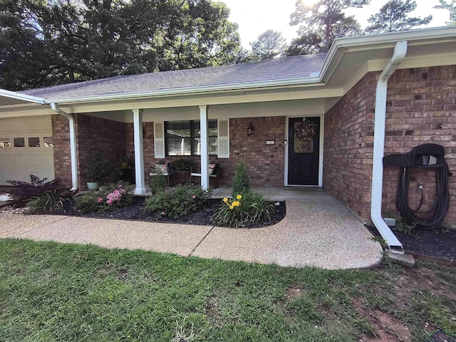 1101 N Idlewood Dr, White Oak, TX 75693 - property entrance with a porch, brick siding, and an attached garage
