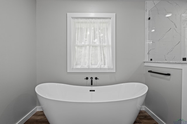 813 Kenwood Ln, Longview, TX 75604 - full bathroom with baseboards, a freestanding tub, and wood finished floors