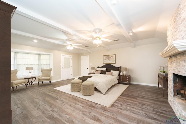 813 Kenwood Ln, Longview, TX 75604 - bedroom with baseboards, wood finished floors, a fireplace, and beamed ceiling