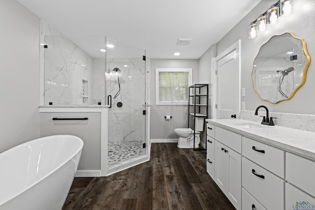 813 Kenwood Ln, Longview, TX 75604 - full bath with a marble finish shower, wood finished floors, toilet, vanity, and a freestanding bath