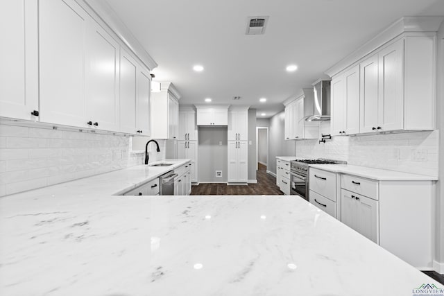 813 Kenwood Ln, Longview, TX 75604 - kitchen featuring wall chimney range hood, a sink, appliances with stainless steel finishes, light stone countertops, and recessed lighting