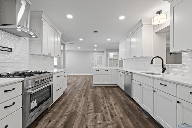 813 Kenwood Ln, Longview, TX 75604 - kitchen featuring appliances with stainless steel finishes, wall chimney exhaust hood, a sink, baseboards, and recessed lighting
