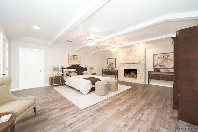 813 Kenwood Ln, Longview, TX 75604 - bedroom featuring wood finished floors, a stone fireplace, beamed ceiling, baseboards, and recessed lighting