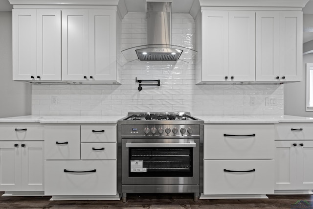 813 Kenwood Ln, Longview, TX 75604 - kitchen with stainless steel range, wall chimney range hood, white cabinetry, and decorative backsplash