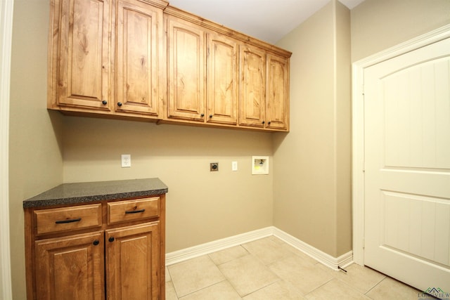 washroom with electric dryer hookup, hookup for a washing machine, light tile patterned floors, and cabinets