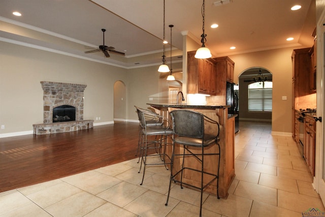 kitchen featuring decorative light fixtures, ceiling fan, ornamental molding, and high end stainless steel range