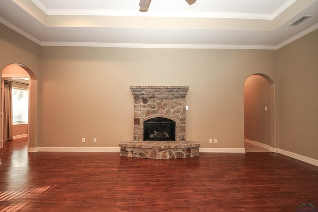 unfurnished living room featuring a fireplace, dark hardwood / wood-style flooring, a raised ceiling, and ornamental molding