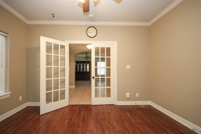 empty room with hardwood / wood-style flooring, ceiling fan, ornamental molding, and french doors