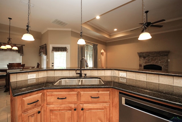 kitchen featuring a raised ceiling, ceiling fan, sink, pendant lighting, and dishwasher