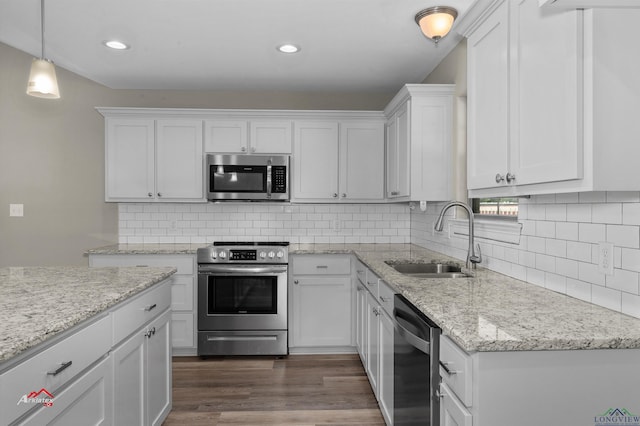 kitchen featuring white cabinets, backsplash, sink, and appliances with stainless steel finishes