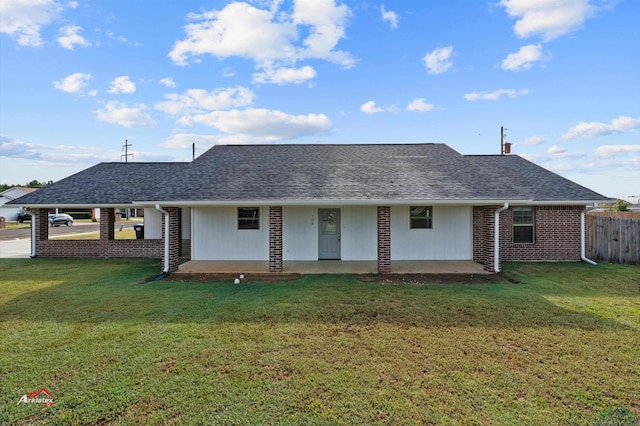 rear view of property featuring a lawn