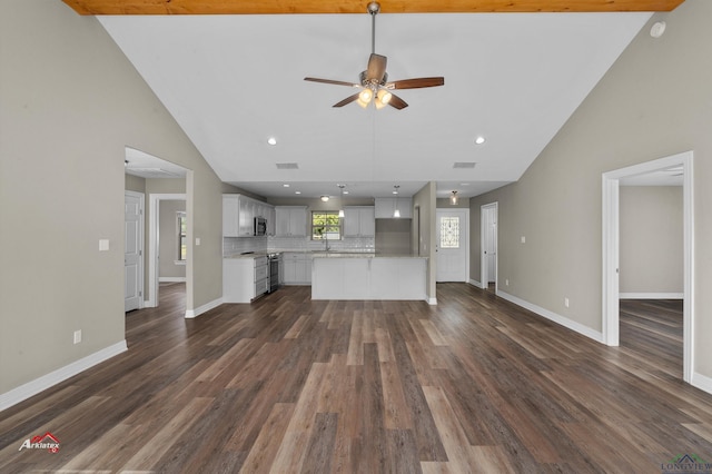 unfurnished living room featuring ceiling fan, dark hardwood / wood-style flooring, sink, and vaulted ceiling