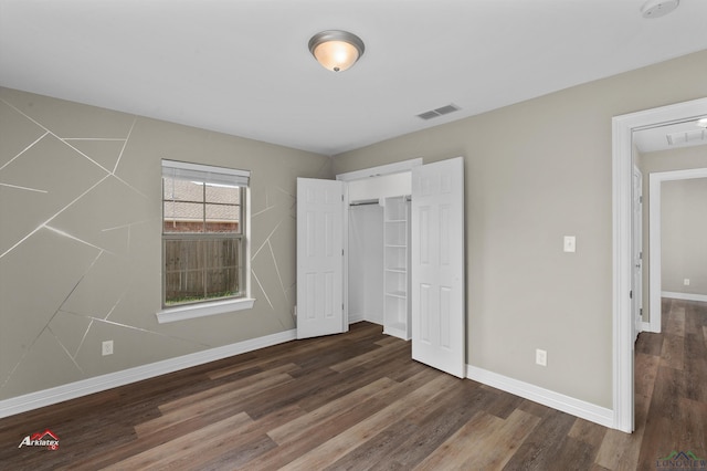 unfurnished bedroom with a closet and dark hardwood / wood-style floors