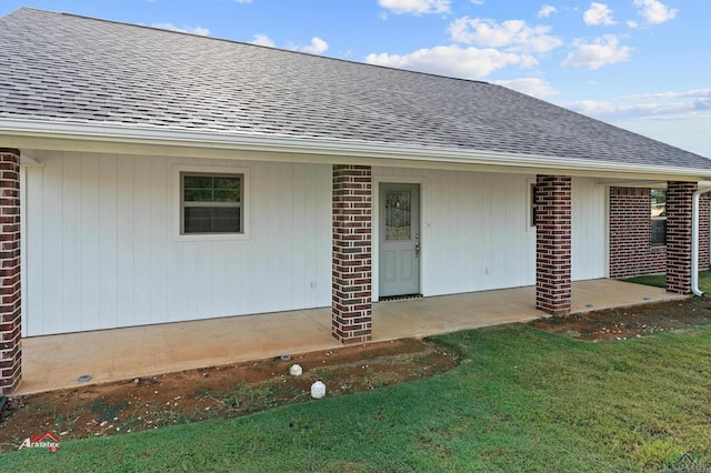 doorway to property with a lawn