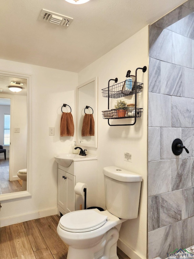 bathroom with hardwood / wood-style floors, vanity, and toilet