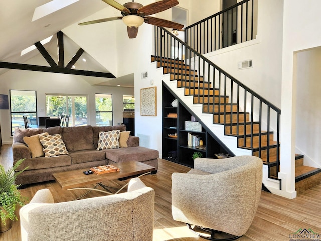 living room with ceiling fan, high vaulted ceiling, and light wood-type flooring
