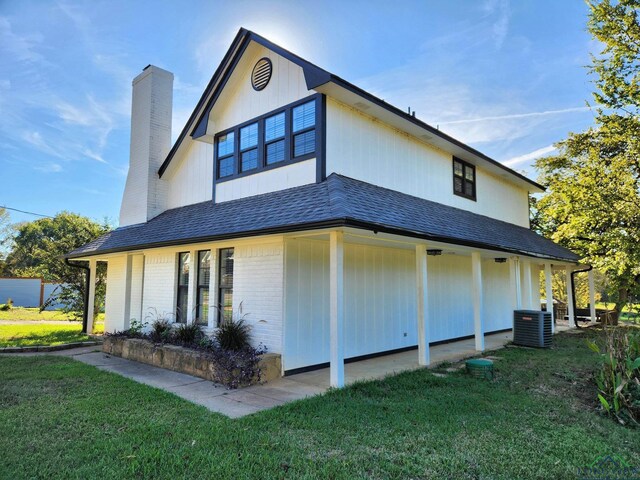 back of property with a lawn and central AC unit