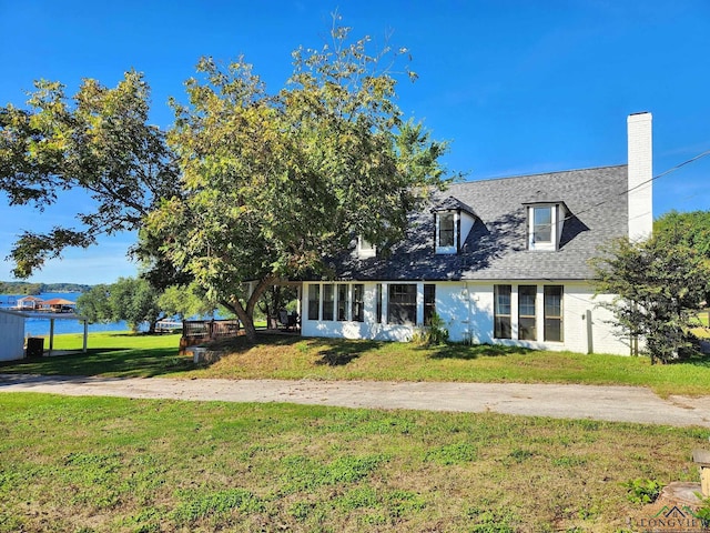 cape cod-style house featuring a front yard