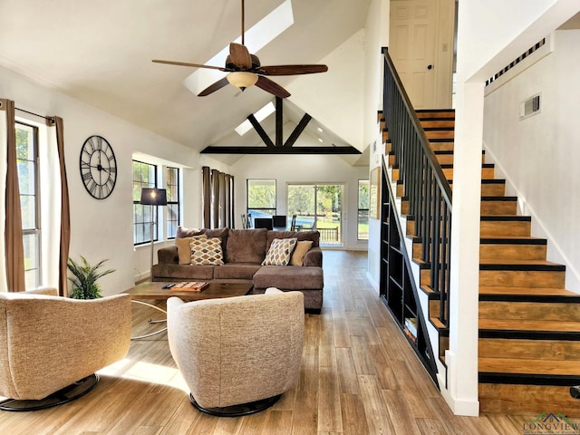 living room featuring light hardwood / wood-style floors, high vaulted ceiling, a wealth of natural light, and ceiling fan