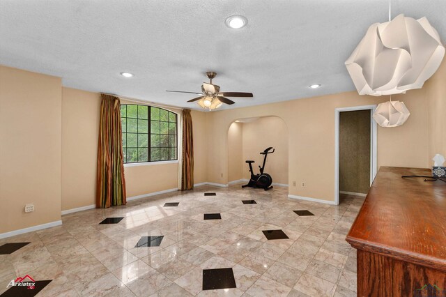 1502 Meandering Way, Longview, TX 75604 - workout room featuring arched walkways, baseboards, ceiling fan, recessed lighting, and a textured ceiling