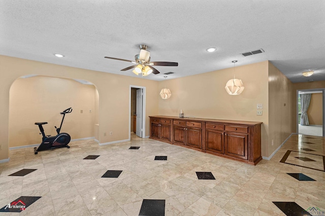 1502 Meandering Way, Longview, TX 75604 - exercise room featuring arched walkways, a ceiling fan, baseboards, a textured ceiling, and recessed lighting