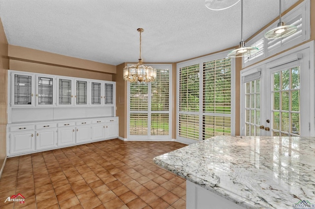 1502 Meandering Way, Longview, TX 75604 - unfurnished dining area with a chandelier, a textured ceiling, and plenty of natural light
