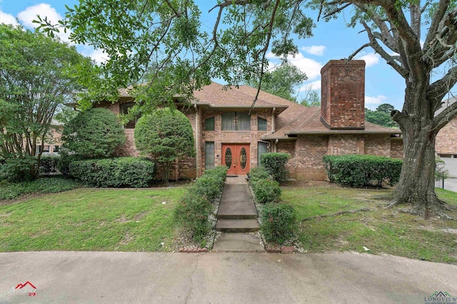 1502 Meandering Way, Longview, TX 75604 - view of front of home featuring french doors, brick siding, a front yard, and a chimney