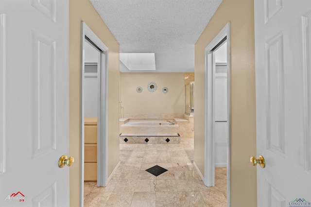 1502 Meandering Way, Longview, TX 75604 - bathroom featuring a spacious closet, baseboards, and a textured ceiling