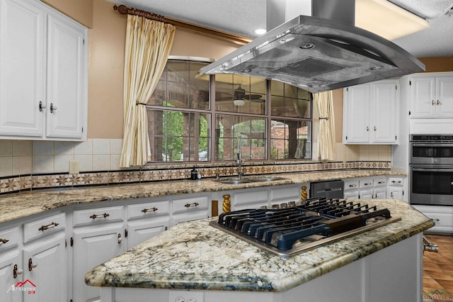 1502 Meandering Way, Longview, TX 75604 - kitchen with stainless steel appliances, island exhaust hood, a kitchen island, a sink, and plenty of natural light