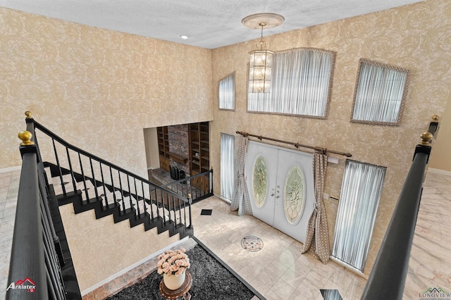 1502 Meandering Way, Longview, TX 75604 - foyer featuring wallpapered walls, a textured ceiling, baseboards, stairway, and a chandelier