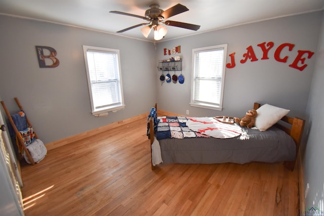 bedroom featuring ceiling fan, light hardwood / wood-style floors, and multiple windows