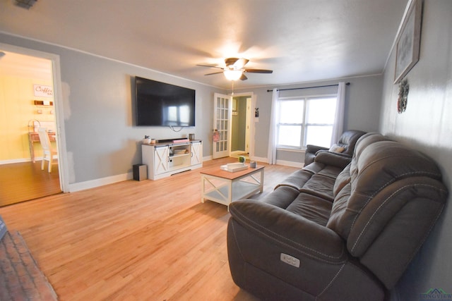 living room with ceiling fan, wood-type flooring, and ornamental molding