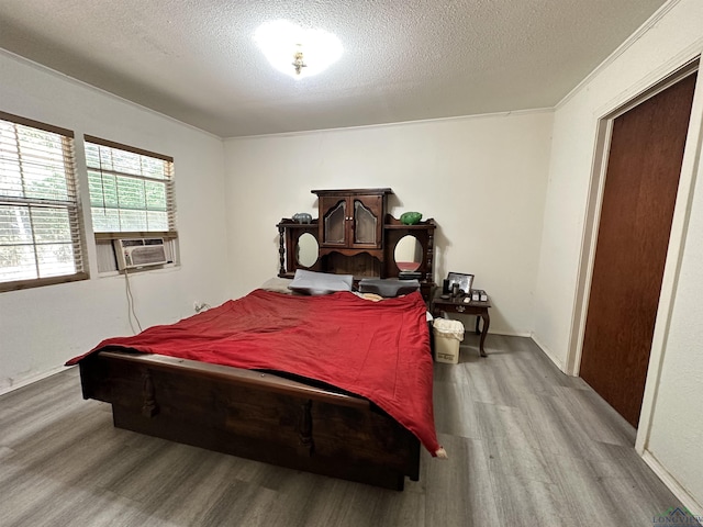 bedroom featuring cooling unit, light wood-type flooring, a textured ceiling, and billiards