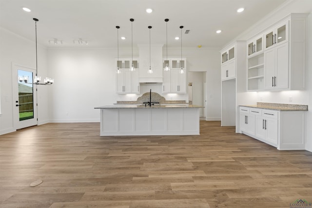 111 Mia Ln, Longview, TX 75604 - kitchen featuring ornamental molding, light wood-style floors, white cabinetry, an island with sink, and a chandelier