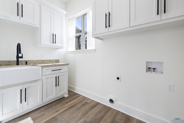 111 Mia Ln, Longview, TX 75604 - laundry room featuring electric dryer hookup, hookup for a washing machine, cabinet space, light wood-type flooring, and baseboards