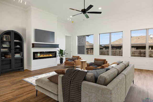 111 Mia Ln, Longview, TX 75604 - living area with ornamental molding, a glass covered fireplace, wood finished floors, baseboards, and recessed lighting