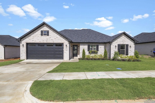 111 Mia Ln, Longview, TX 75604 - french country inspired facade featuring brick siding, a front lawn, concrete driveway, an attached garage, and roof with shingles